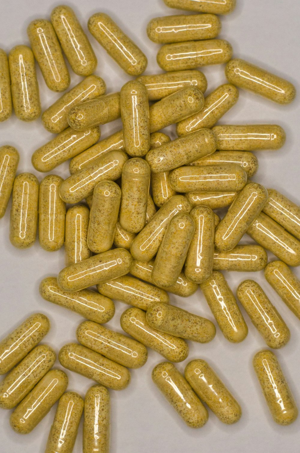 a pile of yellow pills sitting on top of a table