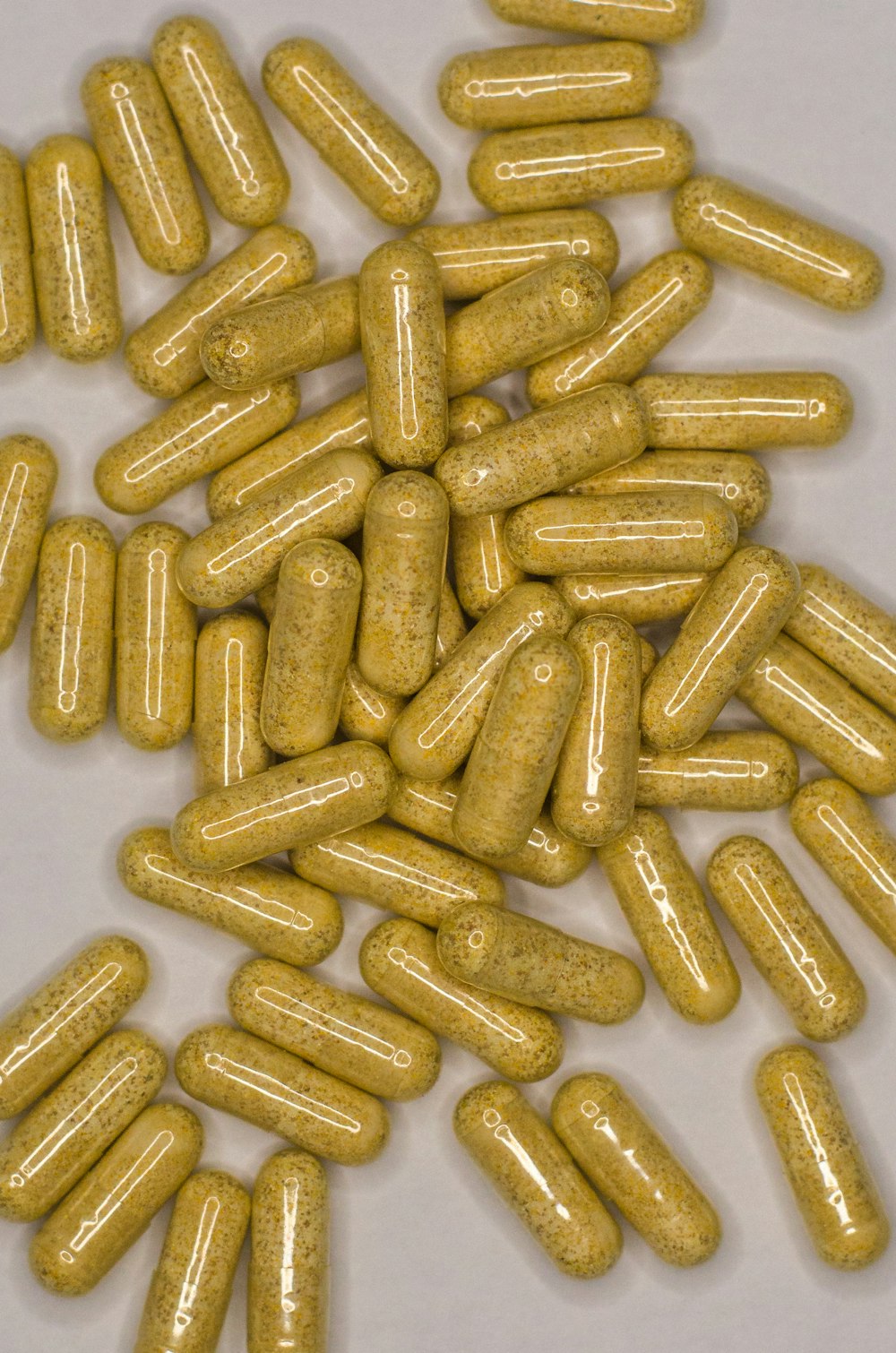 uma pilha de pílulas amarelas sentadas em cima de uma mesa