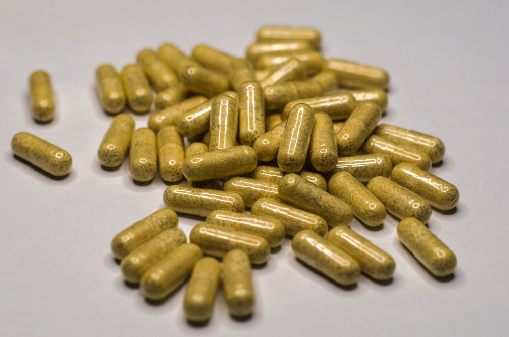 Un montón de píldoras amarillas sentadas encima de una mesa