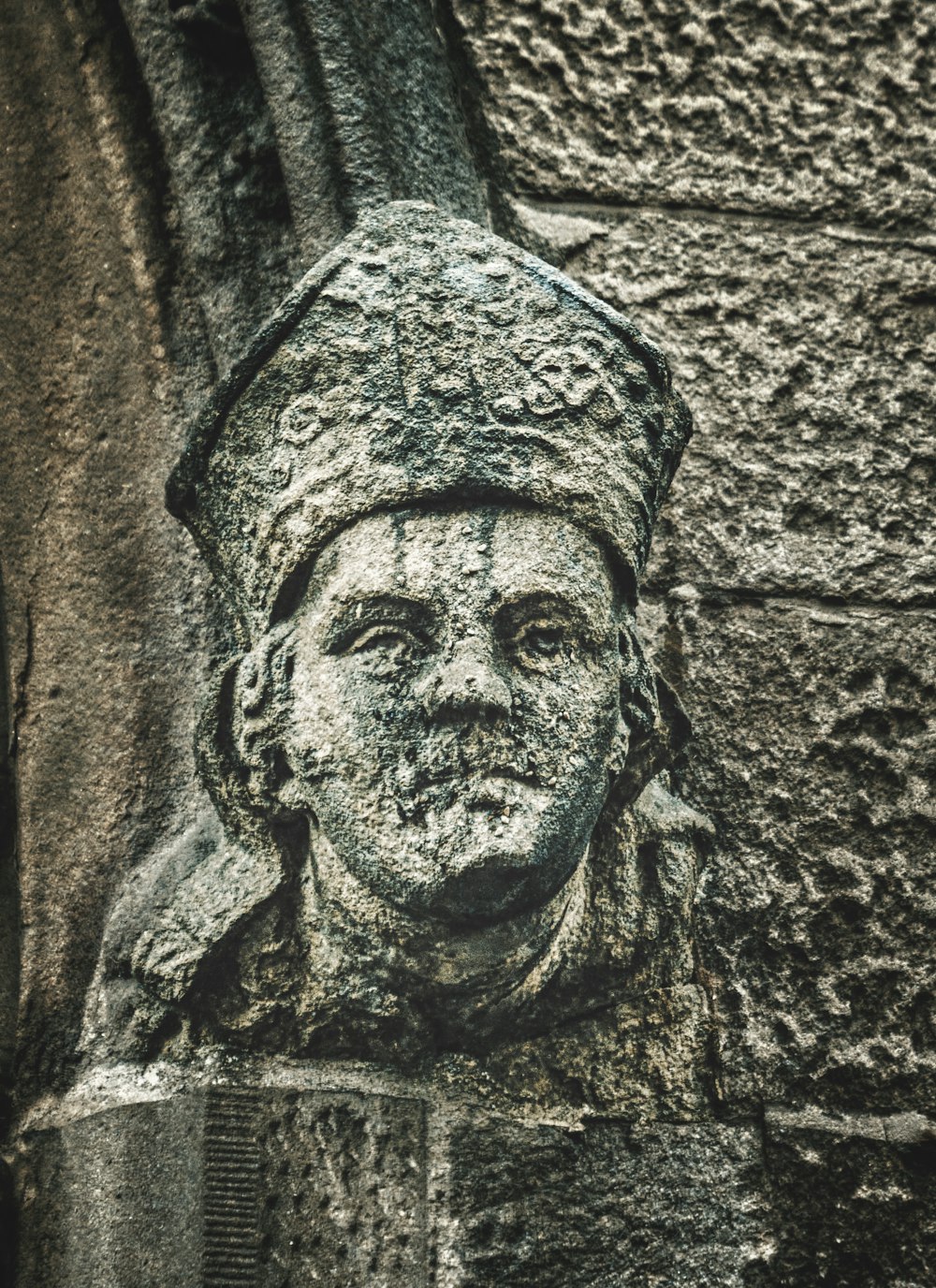 a close up of a statue on the side of a building