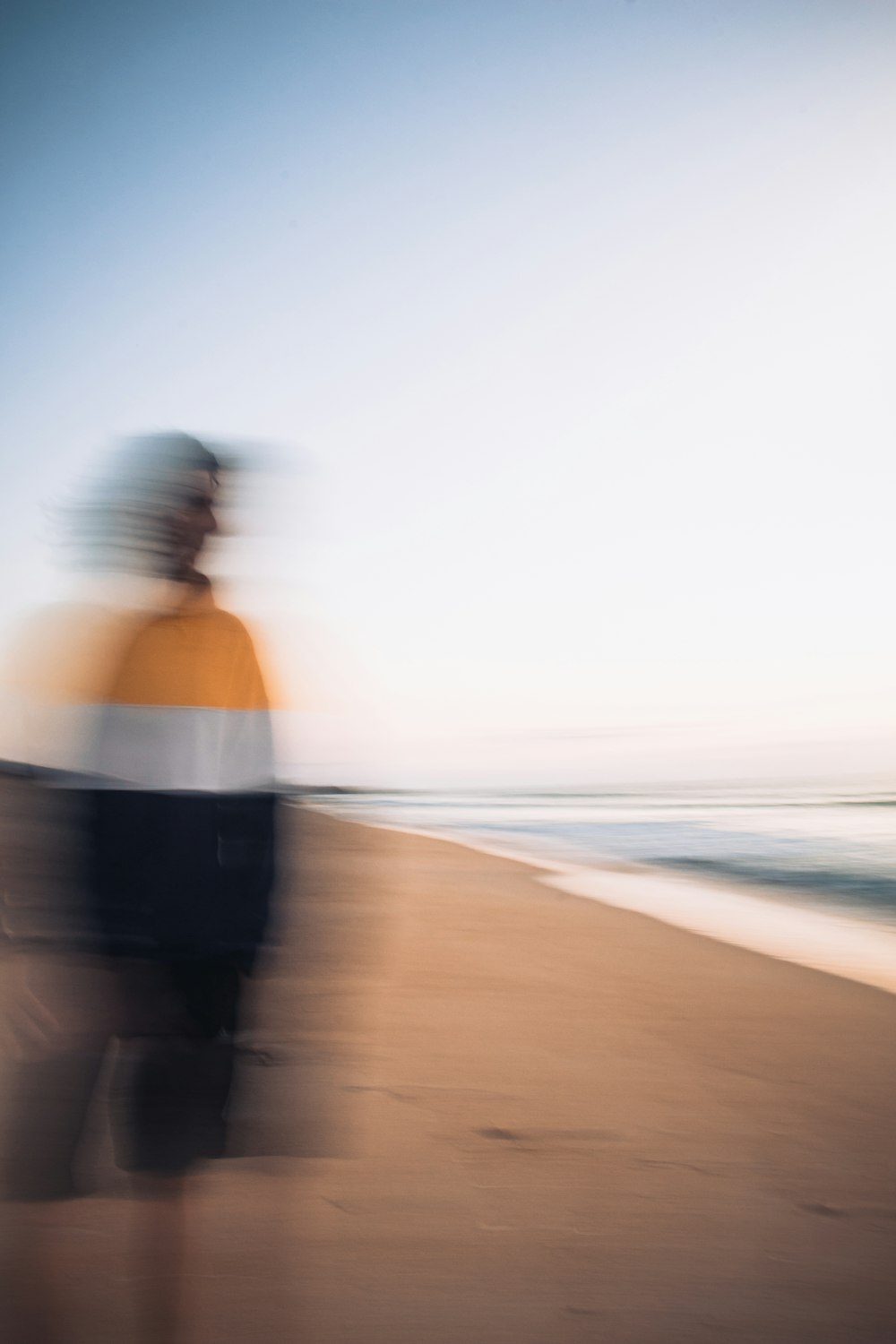 a blurry photo of a person walking on a beach