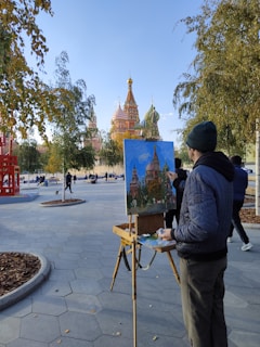 a man standing in front of a painting on a easel