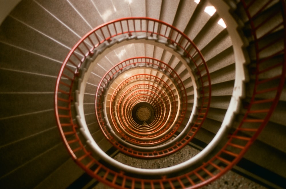 a spiral staircase in a building with red railings