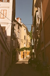 a narrow alley way with buildings and a bicycle parked on the side