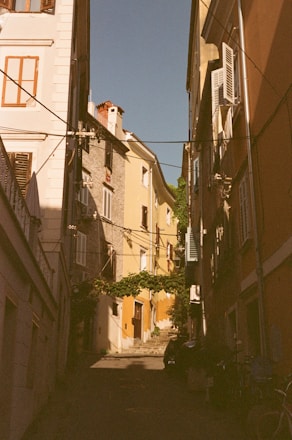 a narrow alley way with buildings and a bicycle parked on the side