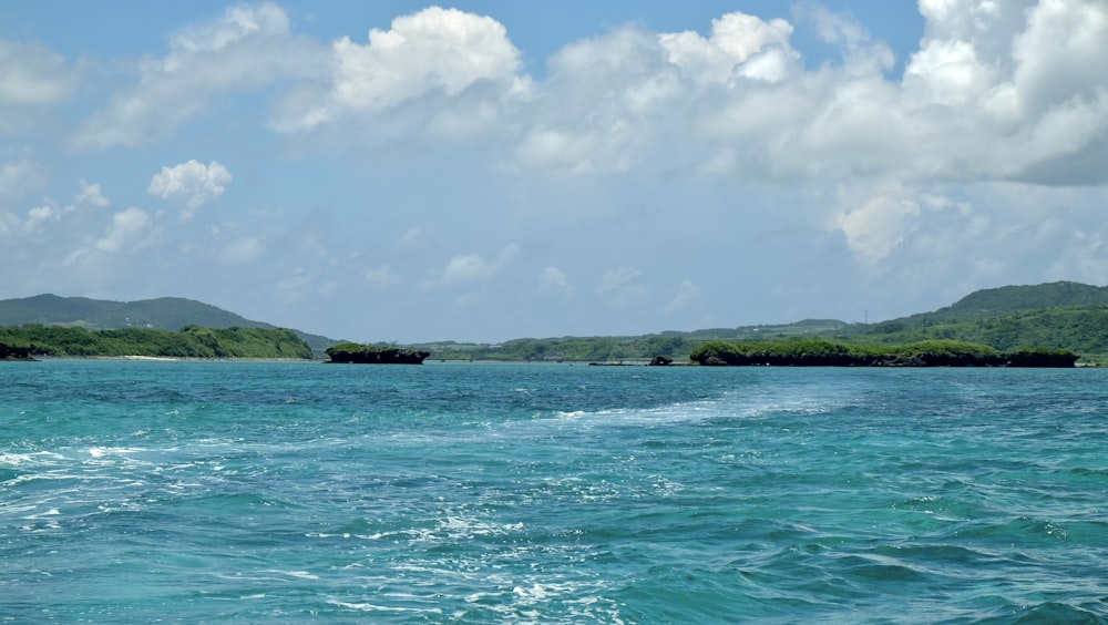 a body of water that has some hills in the background