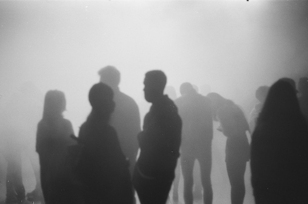 a group of people standing in a foggy area