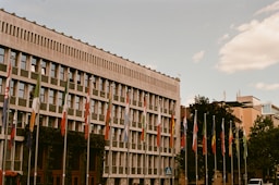 a large building with many flags in front of it