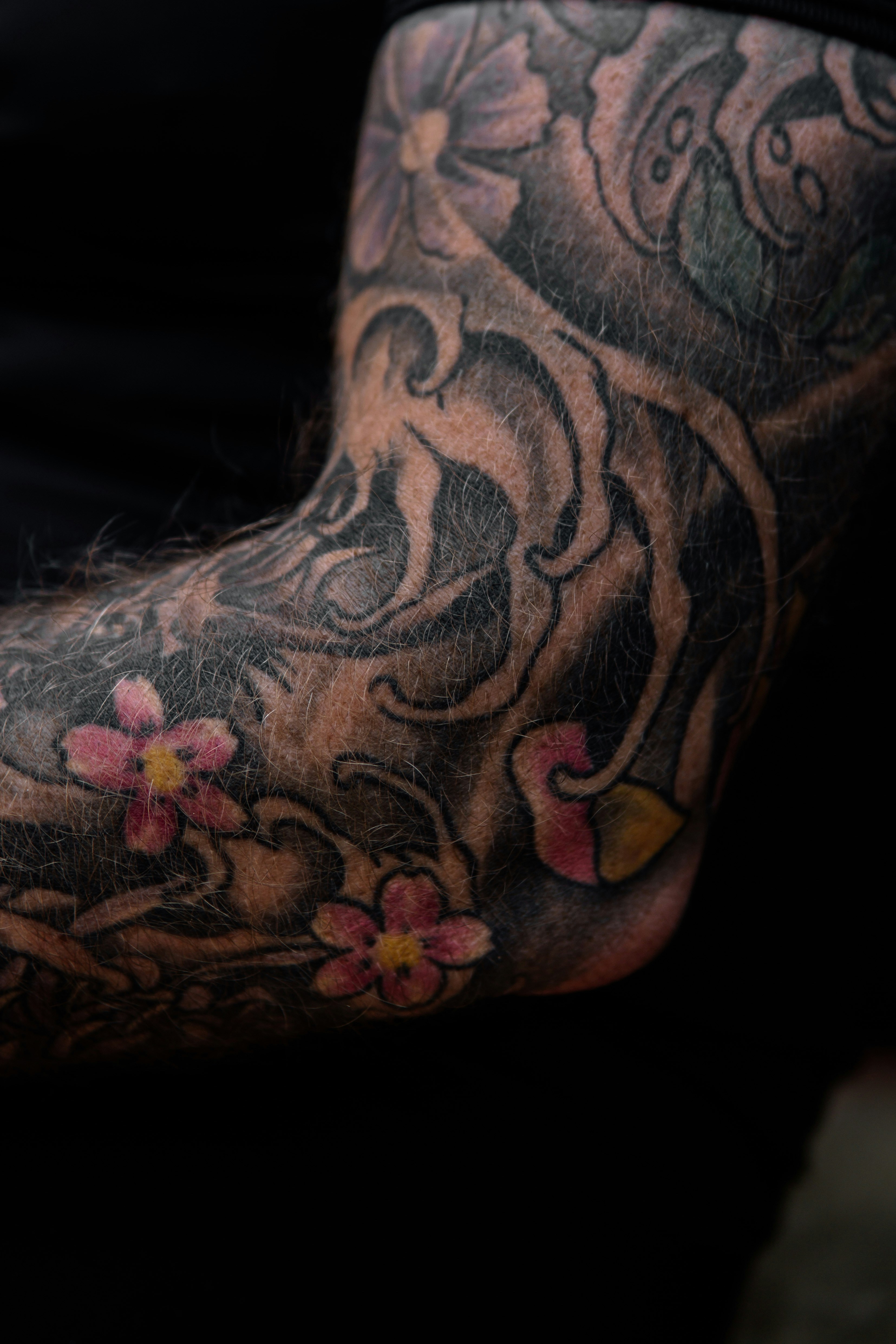 a man with a flower tattoo on his arm