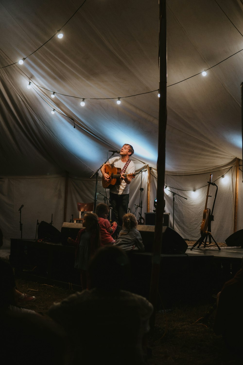 a man standing on a stage with a guitar