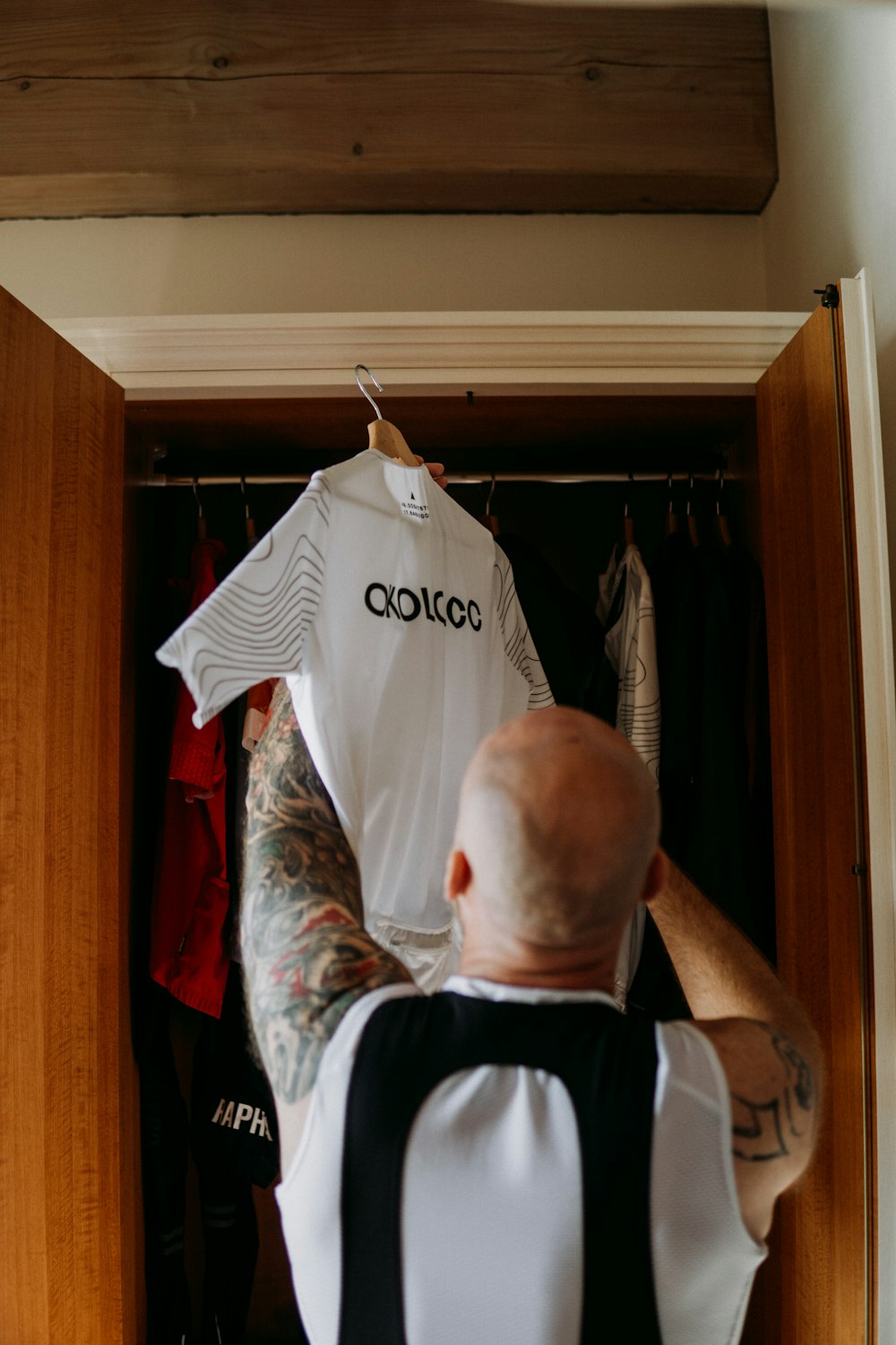 a man with a tattoo on his arm is looking at a shirt