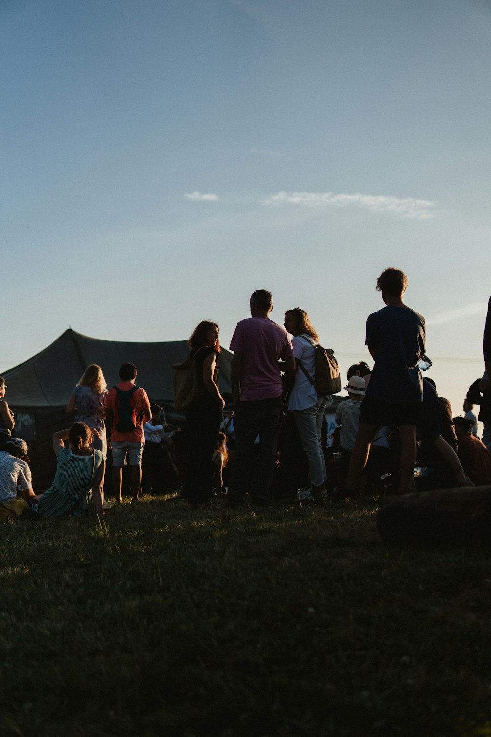 a group of people standing around a tent