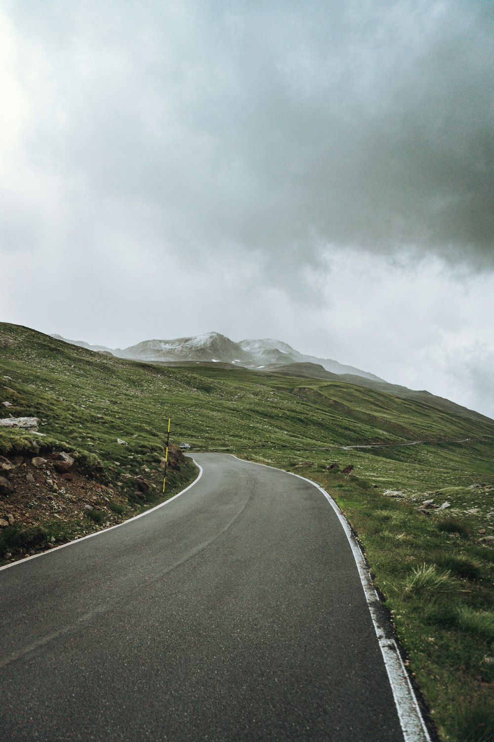 a curved road with a mountain in the background