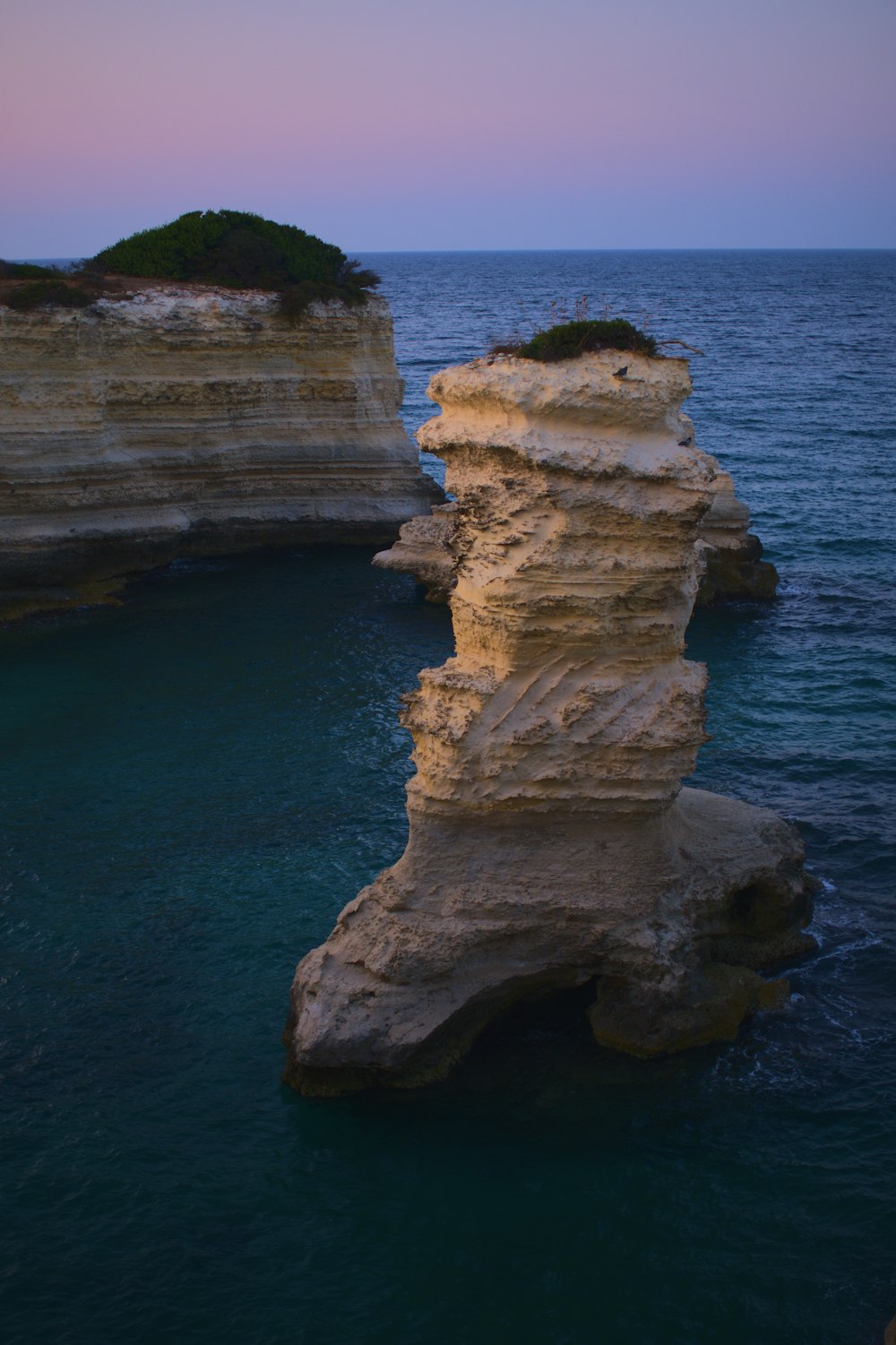 a large rock formation in the middle of a body of water