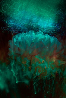 A mesmerizing blend of swirling turquoise and teal colors with abstract patterns resembling floral forms and ethereal light trails. The image creates a sense of mystical energy and movement.