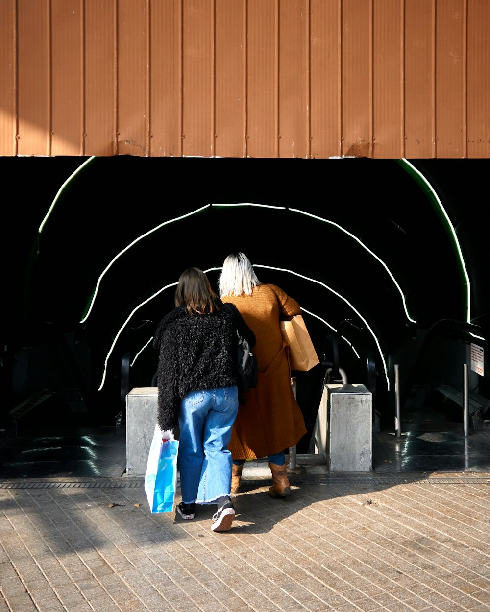 a couple of people that are walking under a tunnel