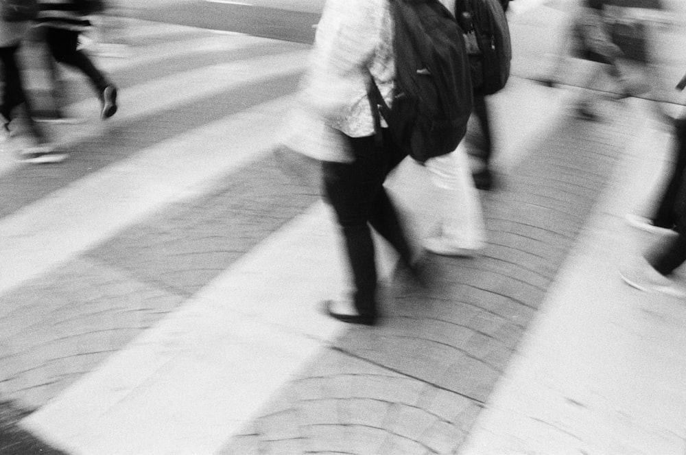 a group of people walking across a cross walk