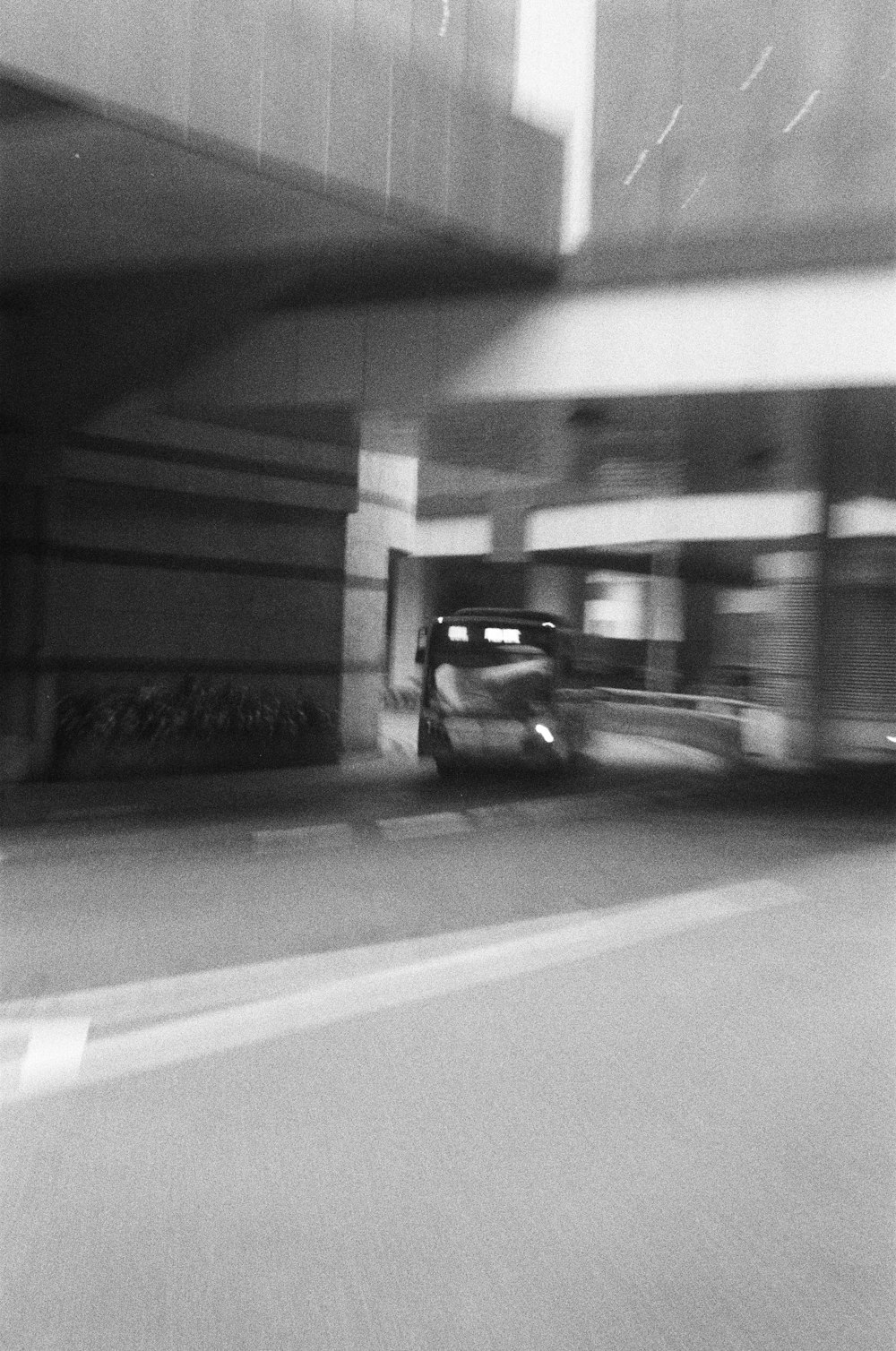 a black and white photo of a car in a parking garage