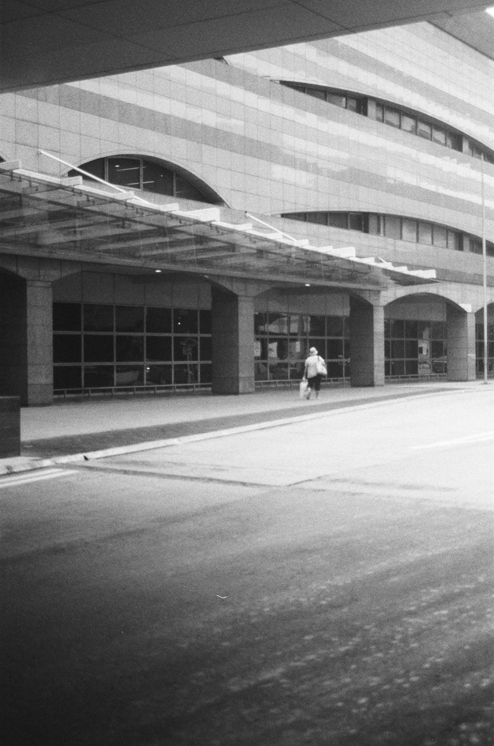 a black and white photo of a person walking down a street