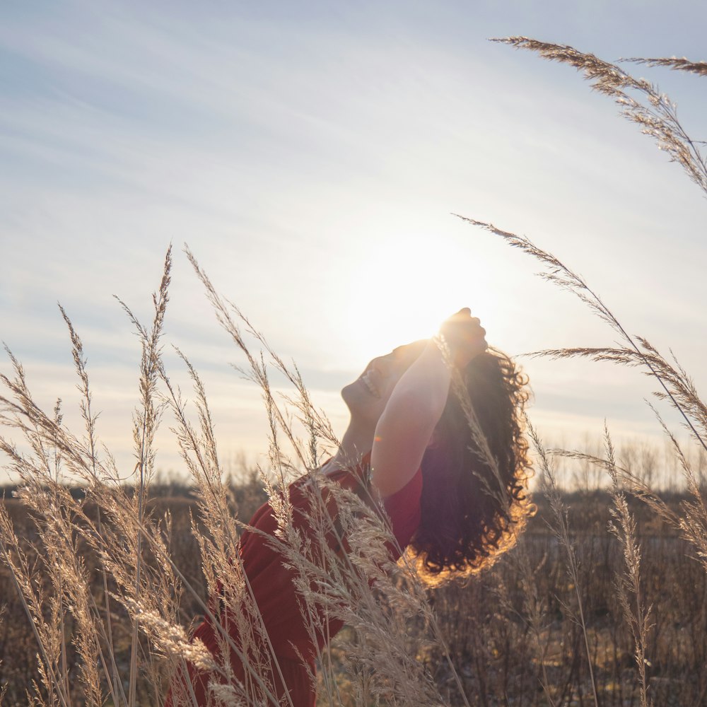 a woman standing in a field of tall grass