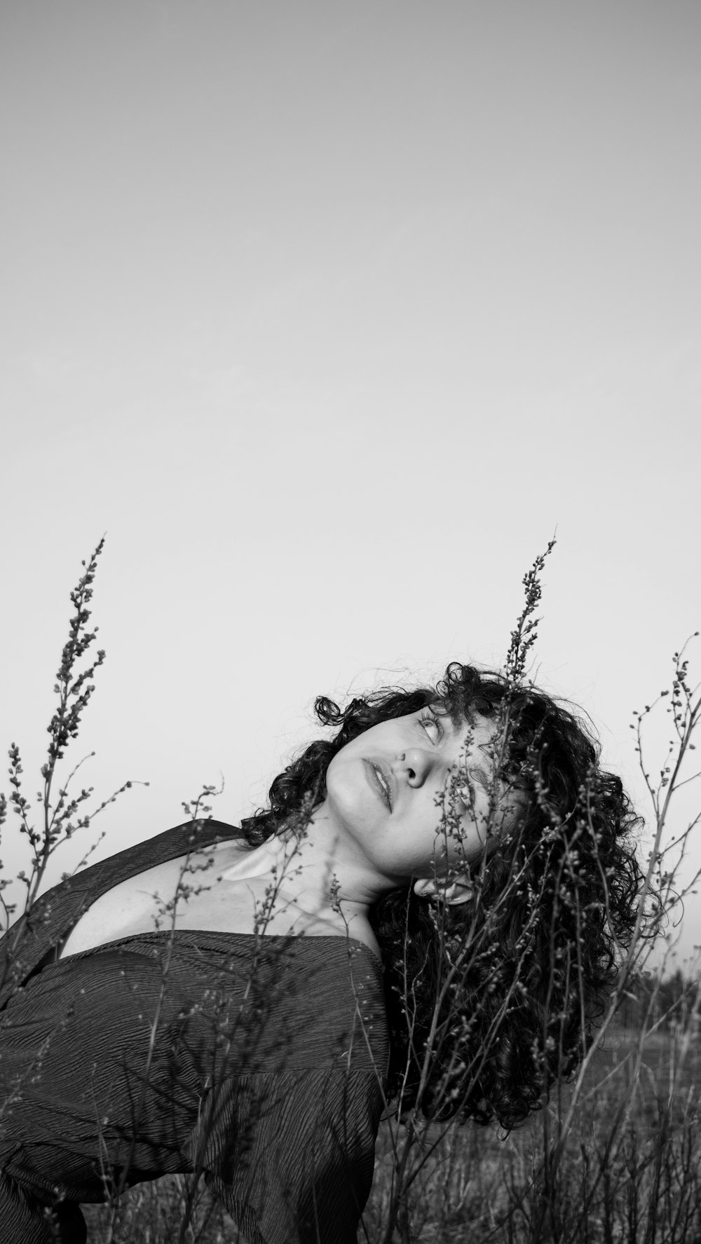 a woman is laying down in a field