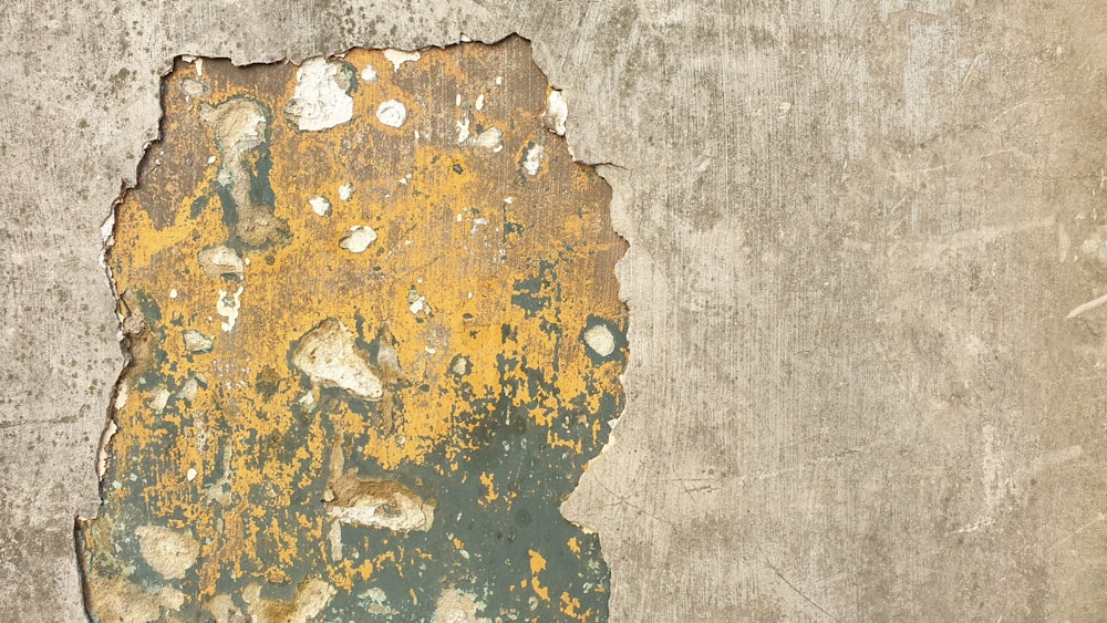 a yellow and green paint chipping on a wall