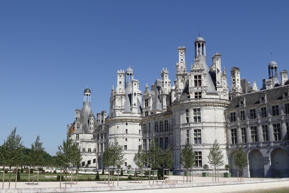 um grande castelo como edifício com uma torre do relógio