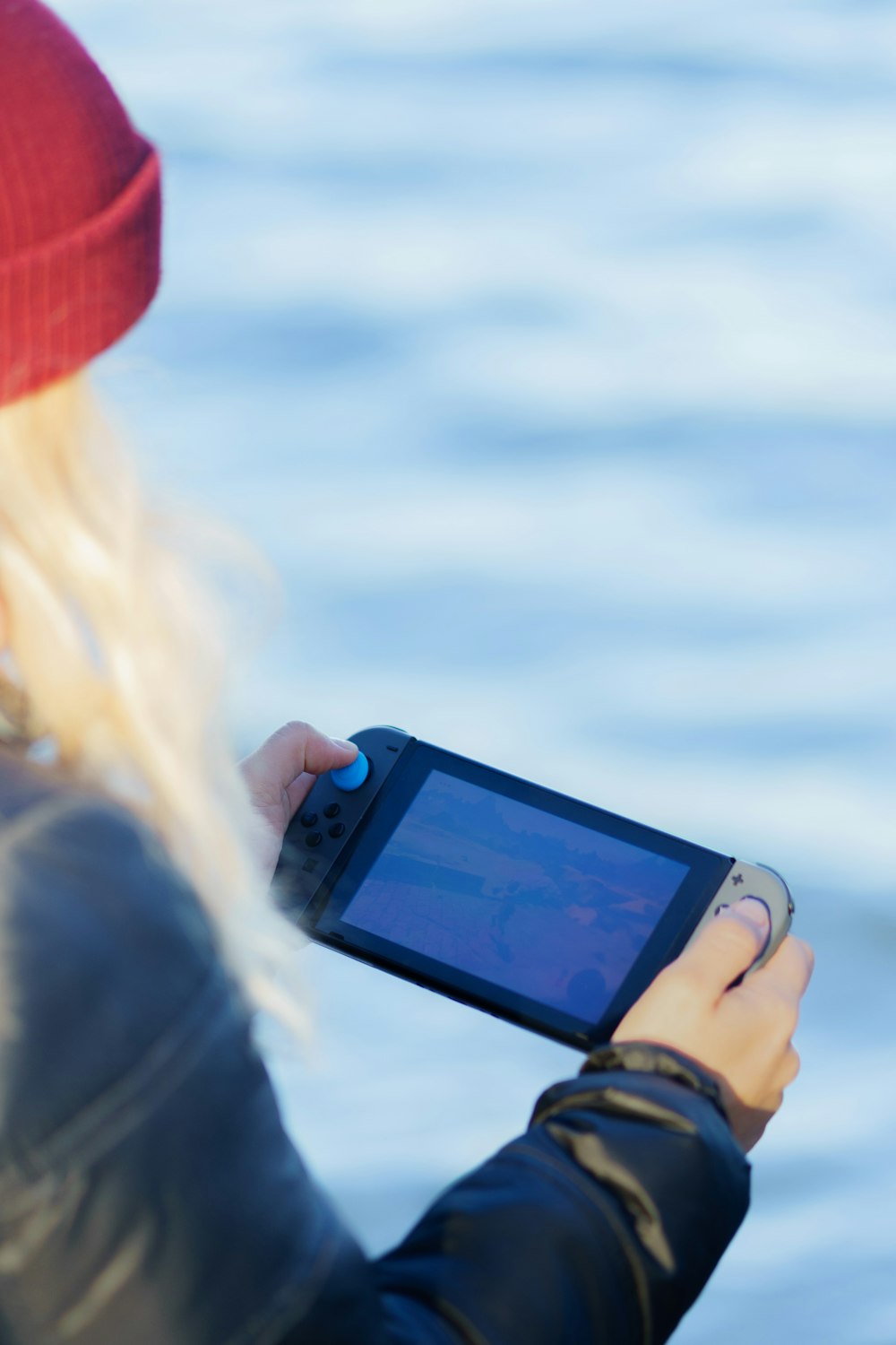 a woman in a red hat is holding a cell phone