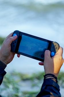 a person holding a nintendo wii game controller