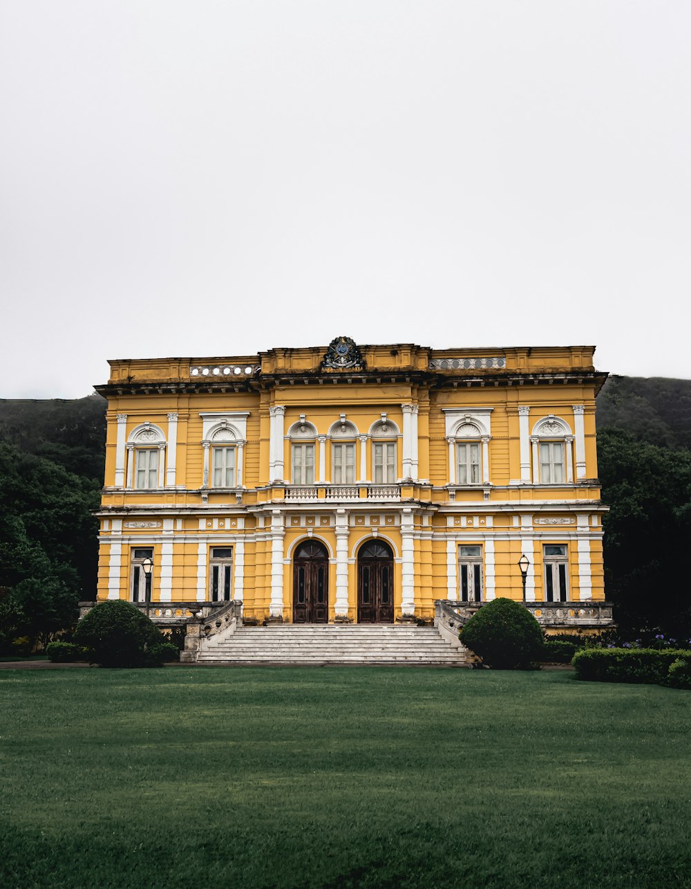 a large yellow building sitting on top of a lush green field