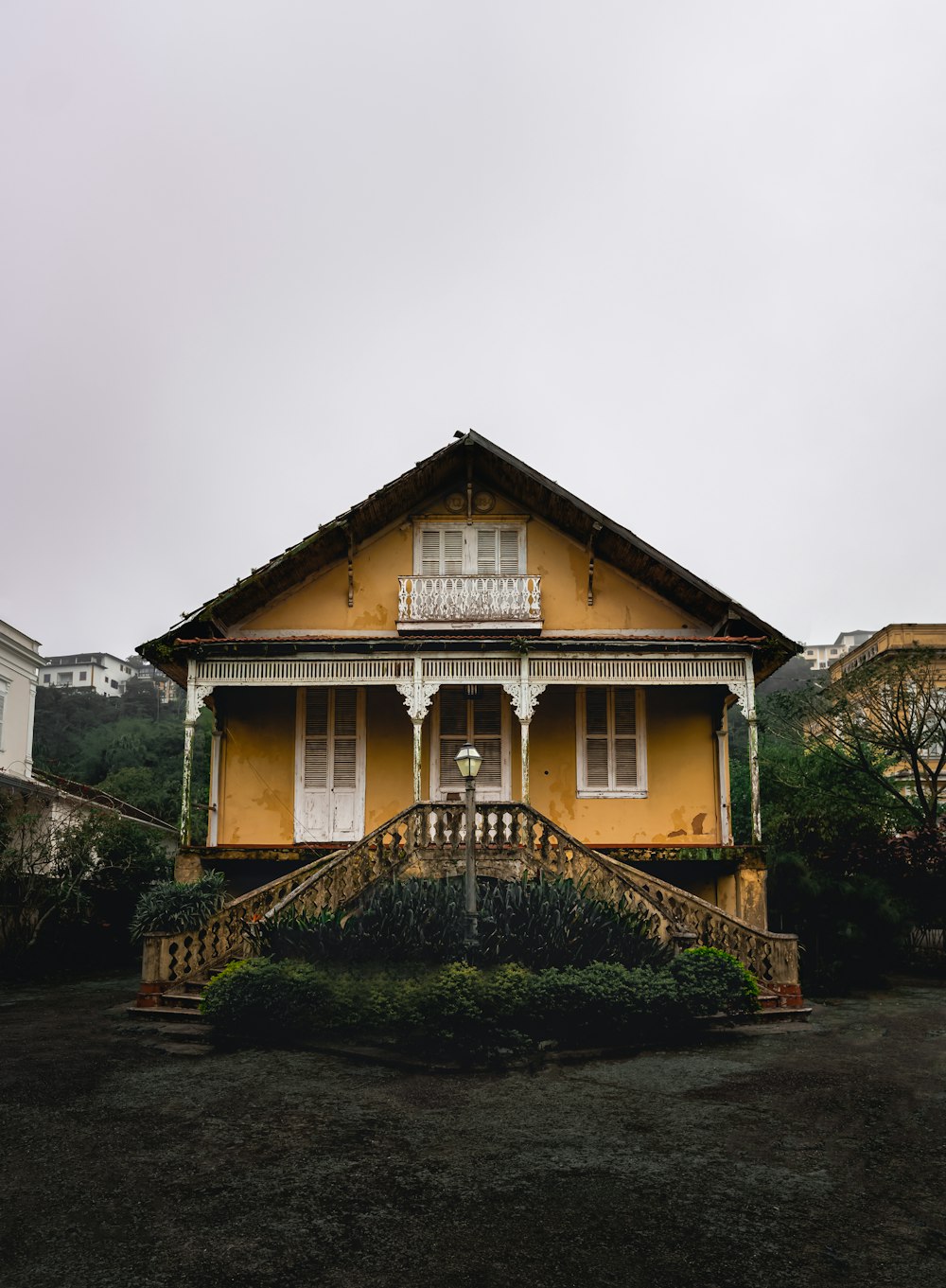 a yellow house with a white balcony and balconies