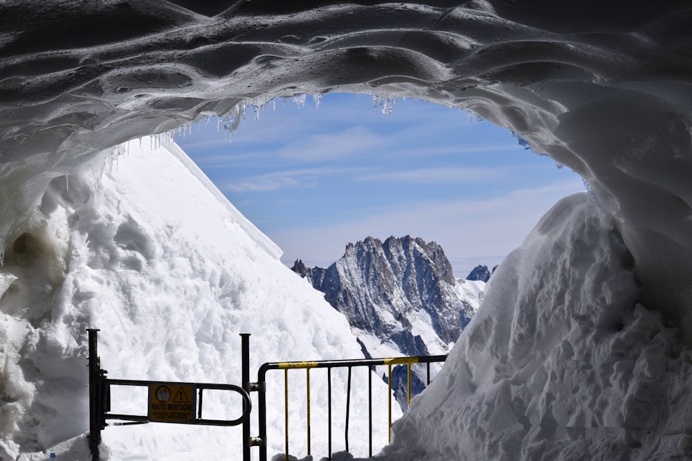 a view of a snowy mountain from inside a cave