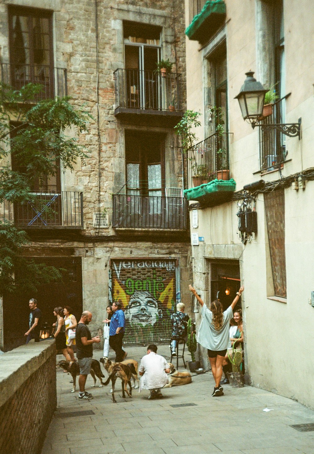 a group of people walking down a street next to tall buildings