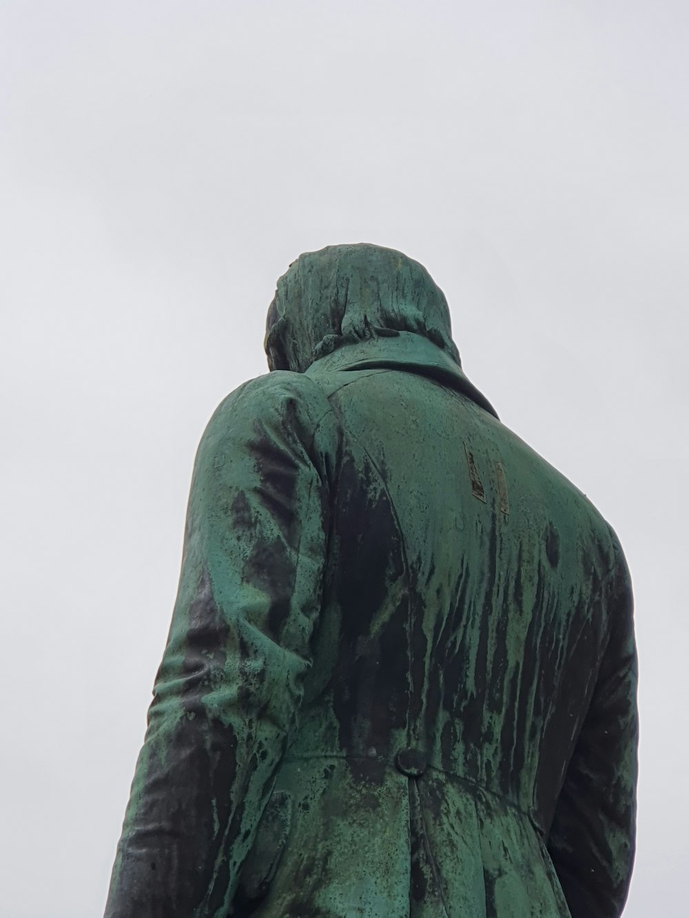 a statue of a person wearing a green coat
