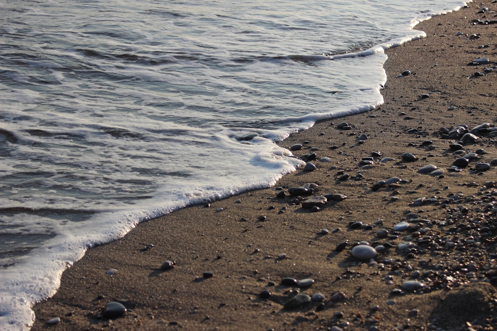 a sandy beach with waves coming in to shore