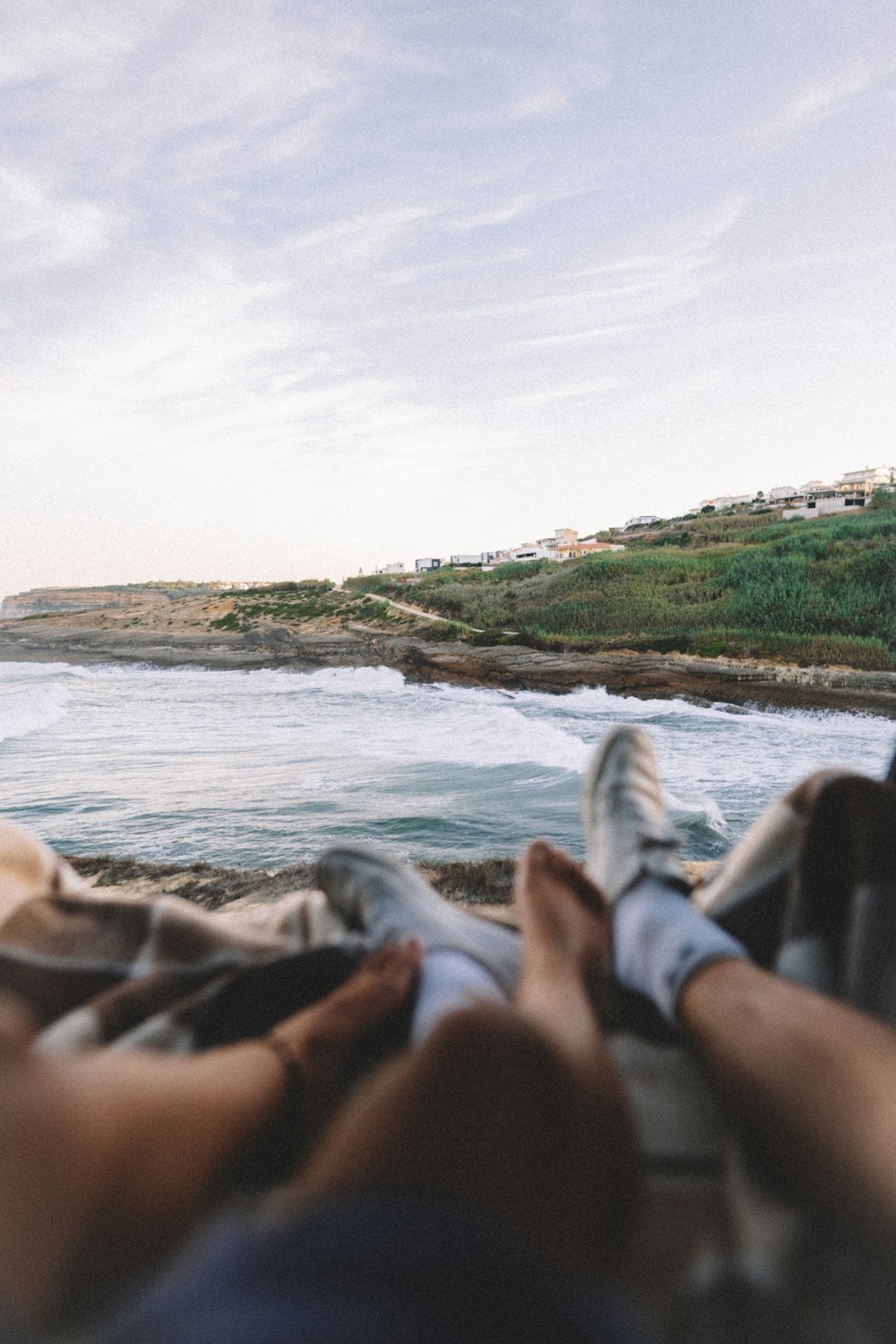 a person laying on a beach next to a body of water