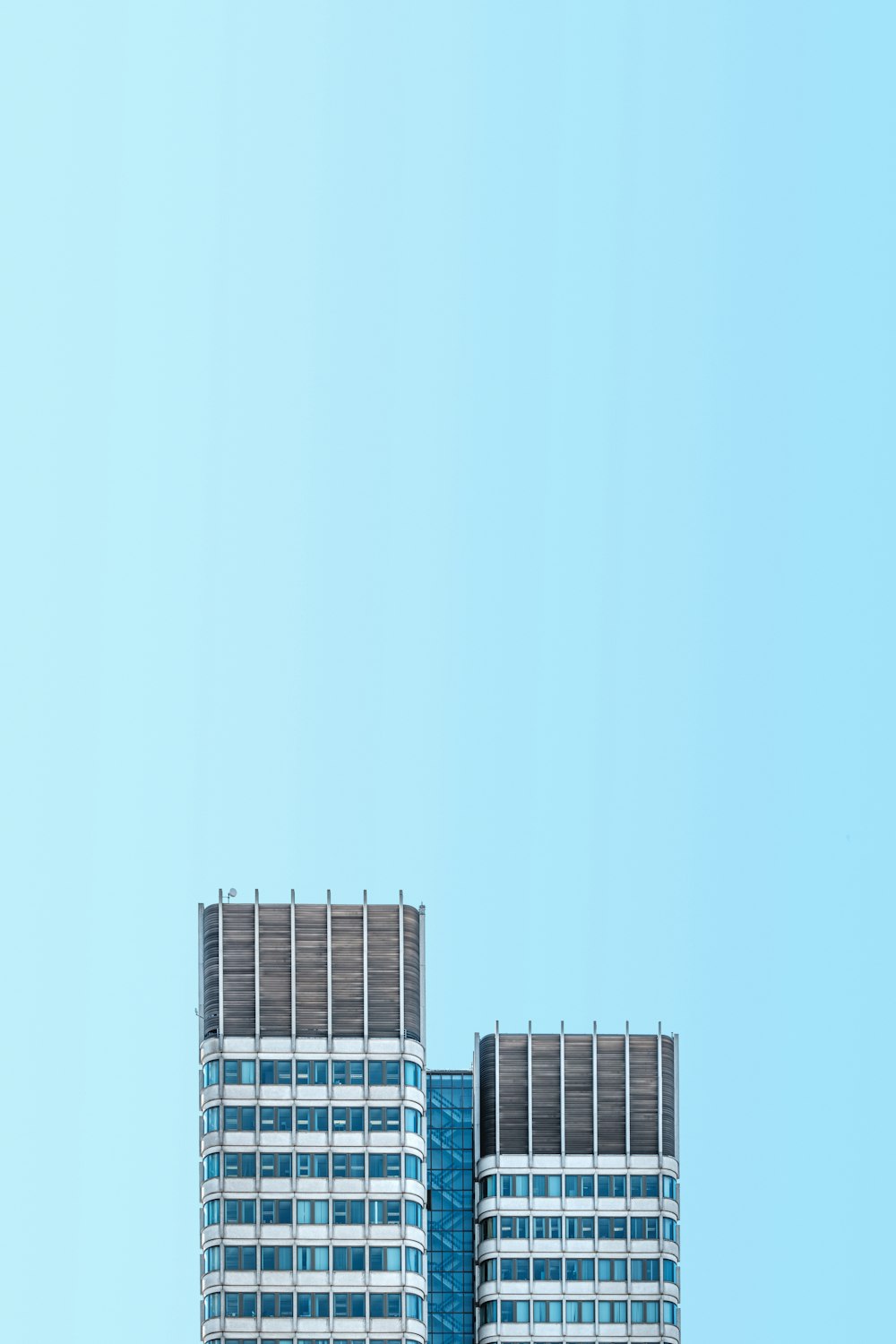a plane flying over a tall building on a clear day