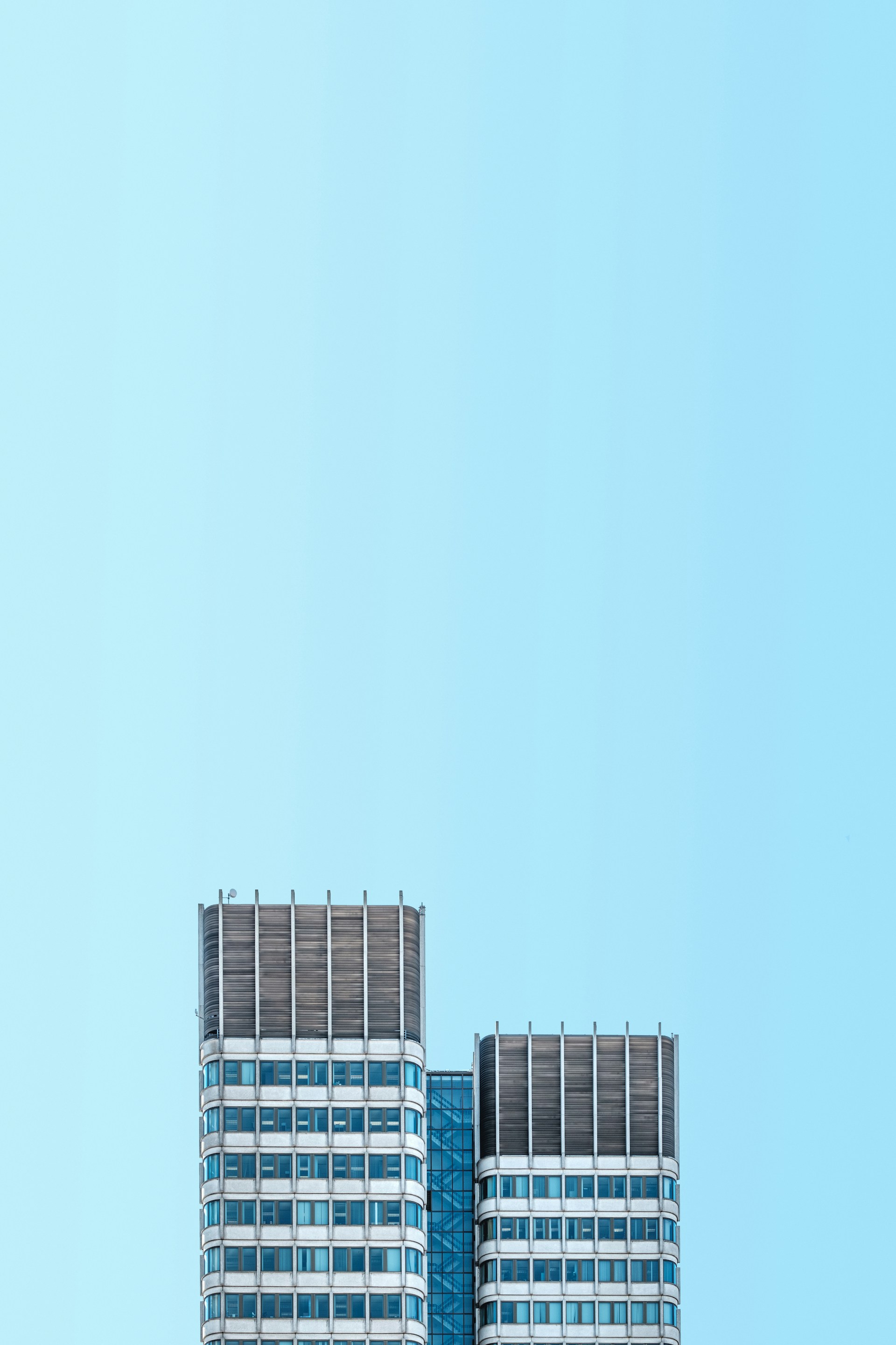 a plane flying over a tall building on a clear day