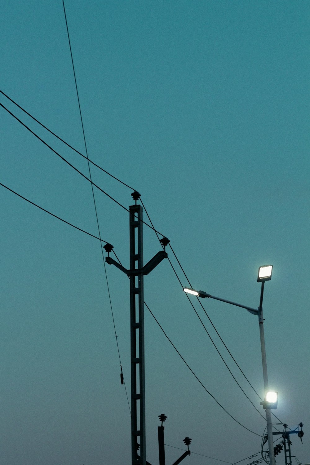 a street light and some power lines with a sky background