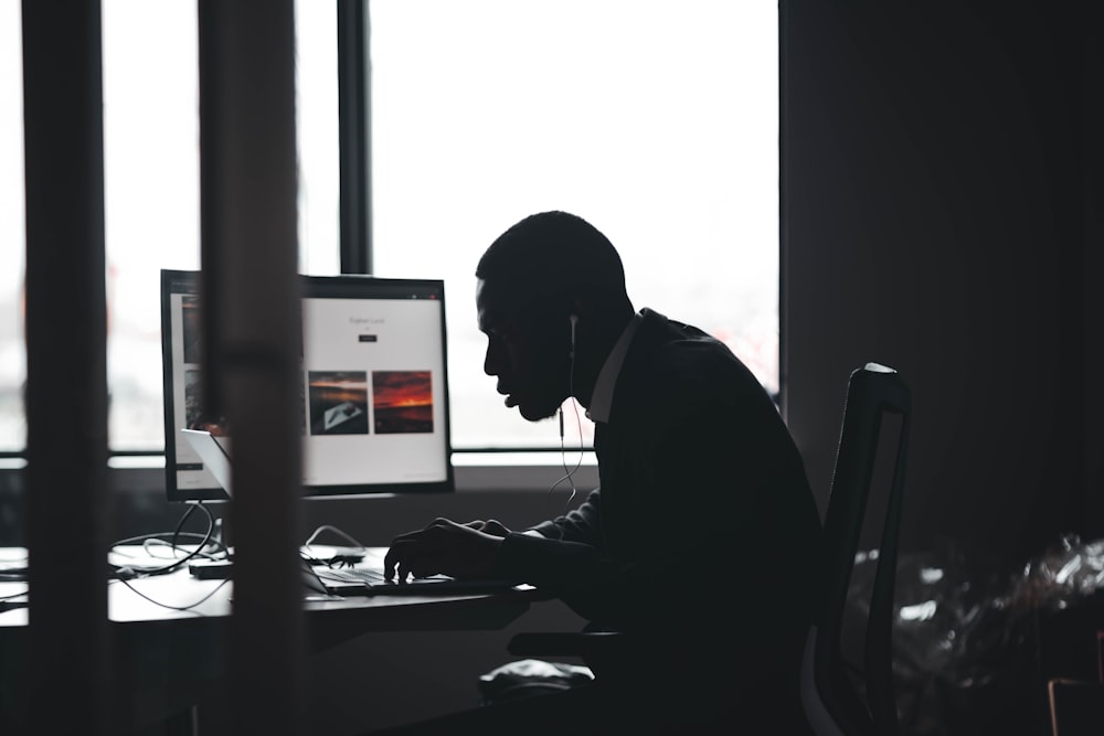 a man sitting at a desk using a computer