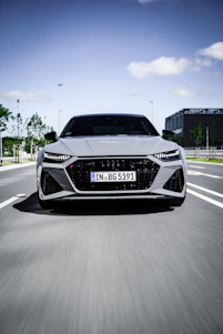 A sleek vehicle on a city highway with a blue virtual GPS wave tracking its movement.