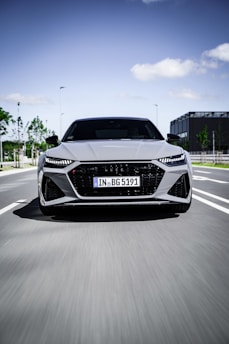 A sleek modern car driving through a cityscape at dusk, highlighting speed and comfort.