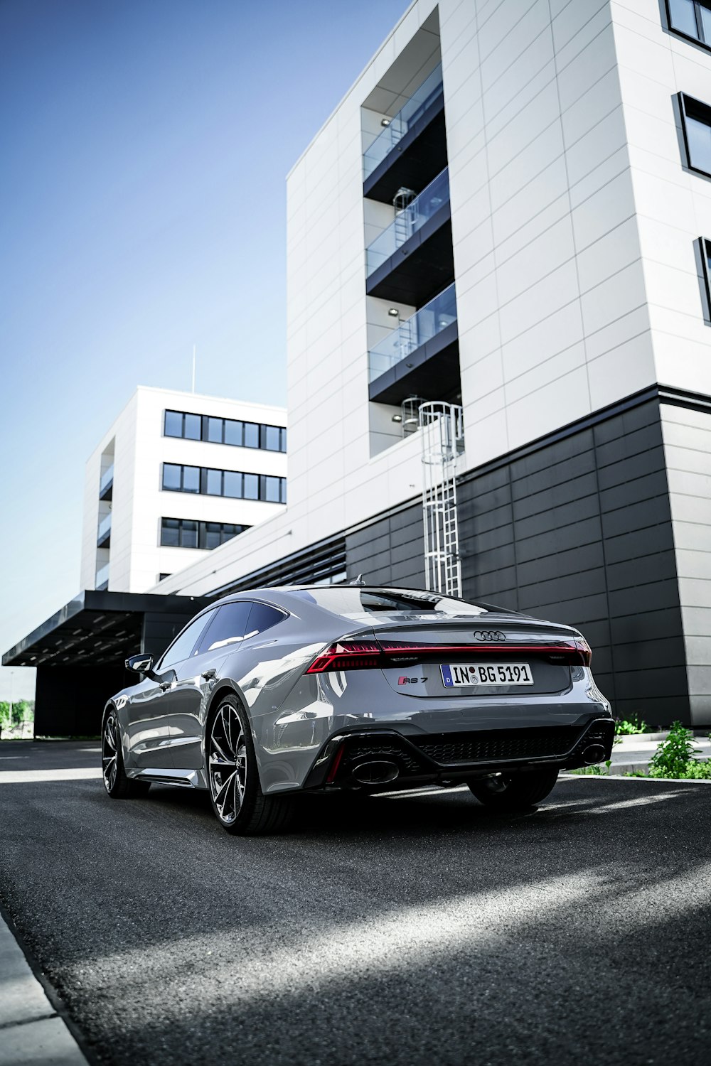 a silver sports car parked in front of a building