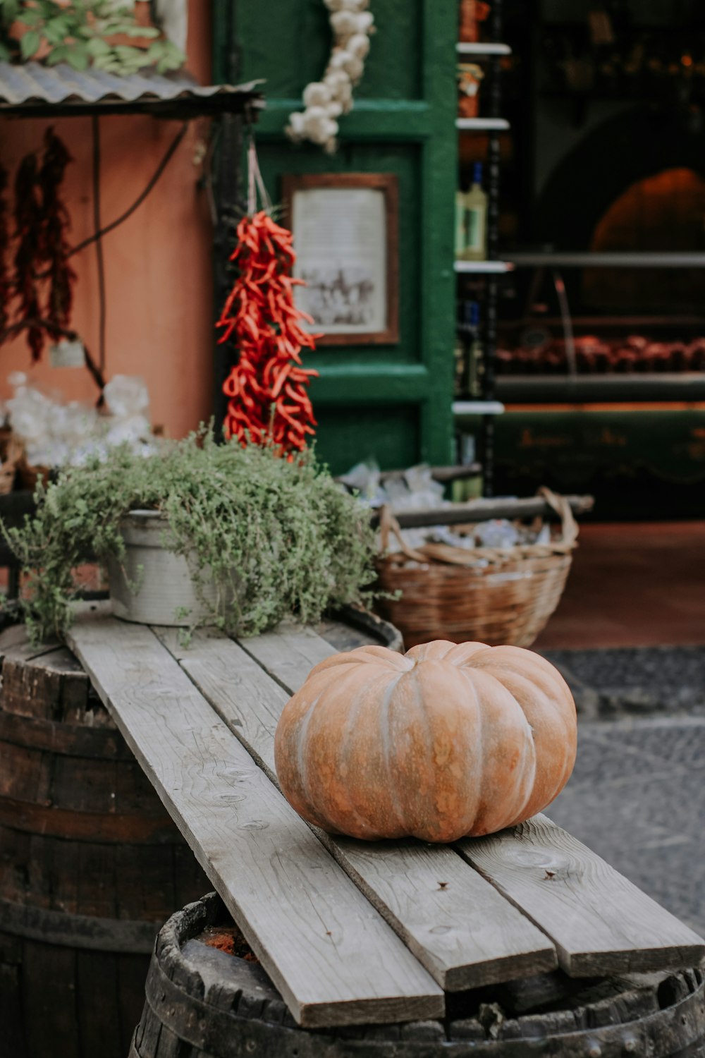 a wooden table topped with a pumpkin sitting on top of a barrel