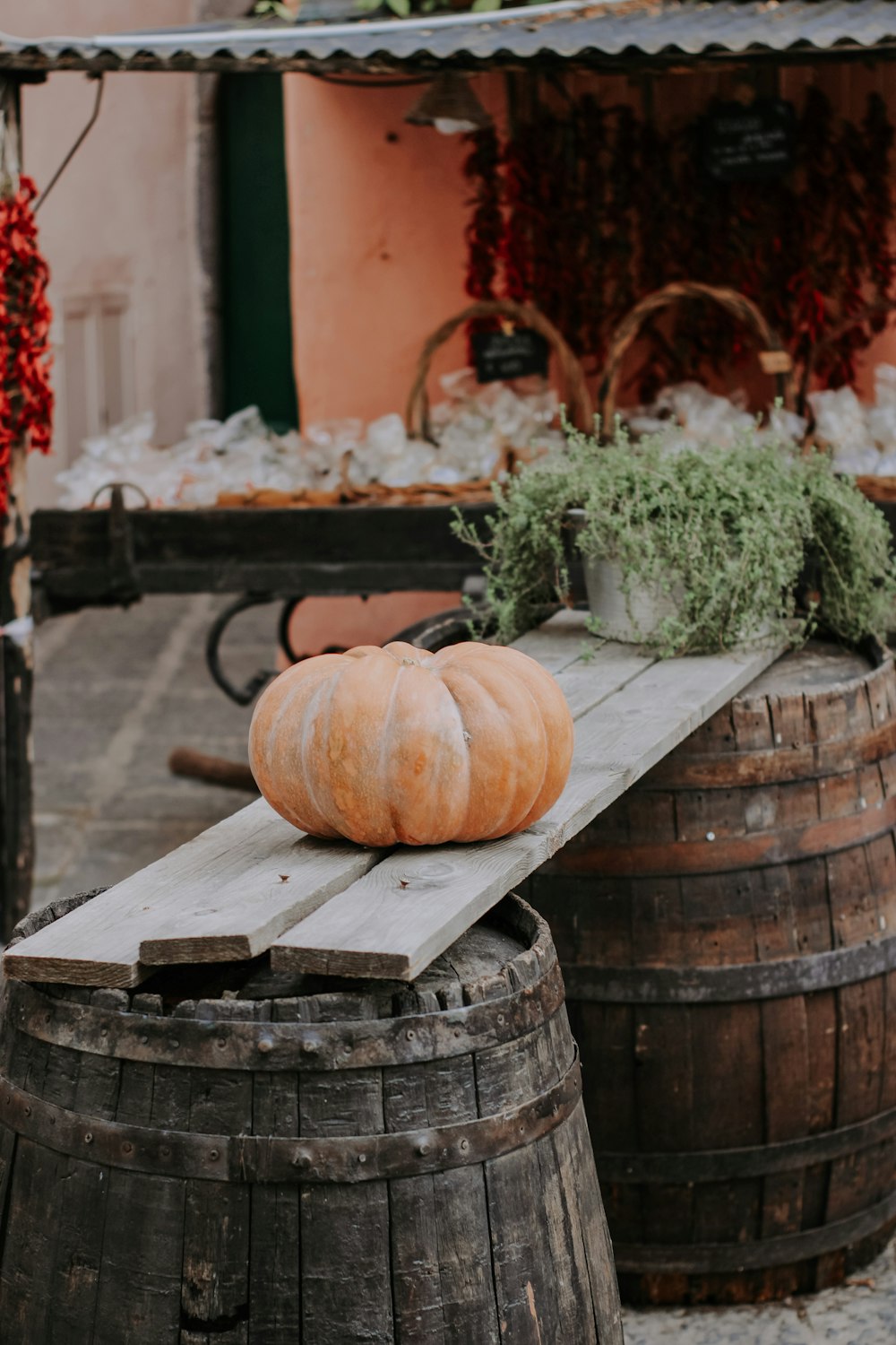 a pumpkin sitting on top of a wooden barrel