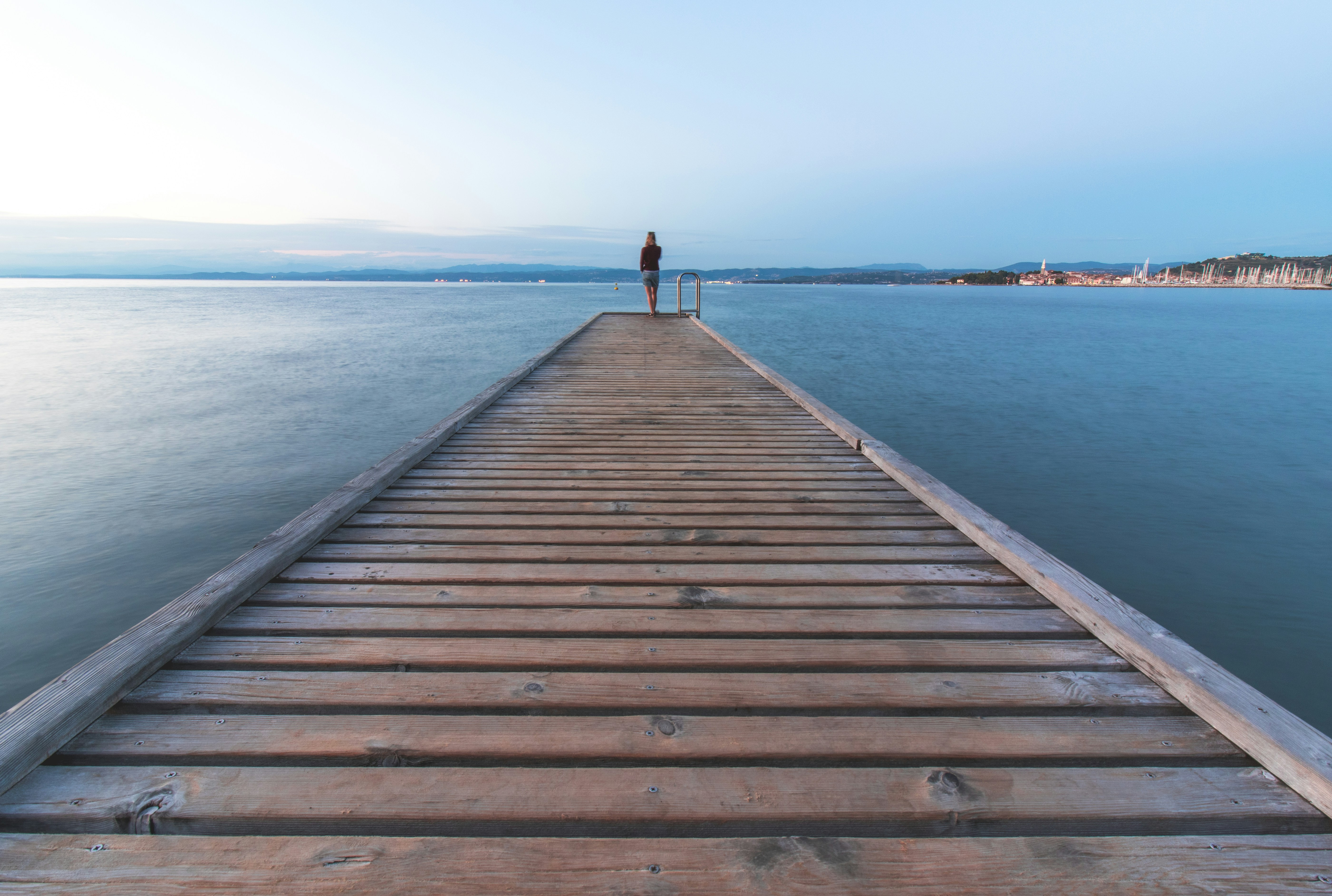 a person standing on a pier looking out at the water