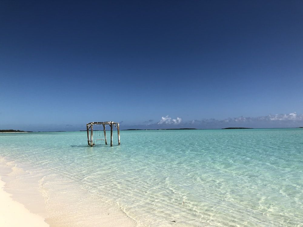 an empty beach with a gazebo in the water
