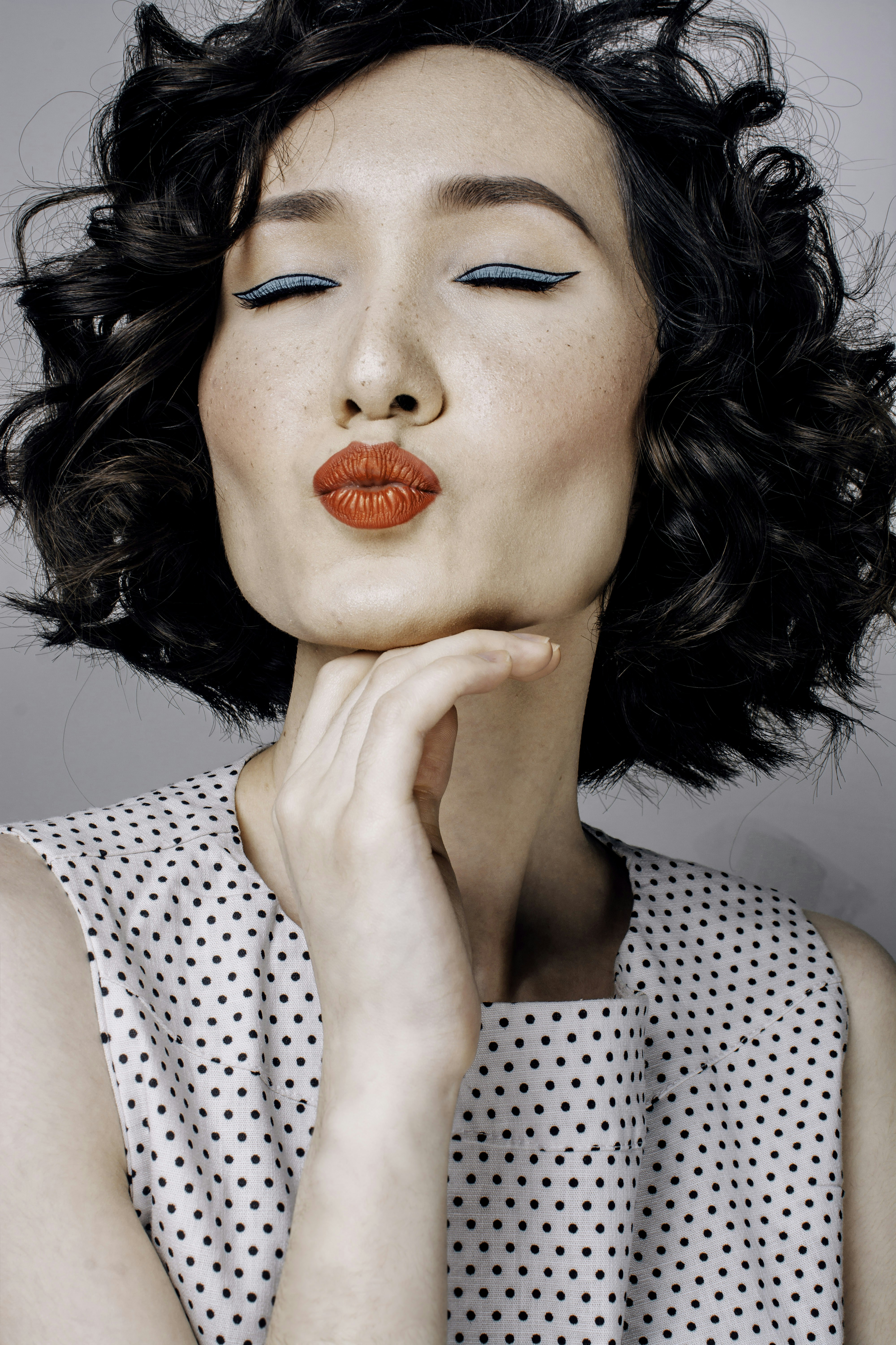 a woman with black hair and orange lipstick