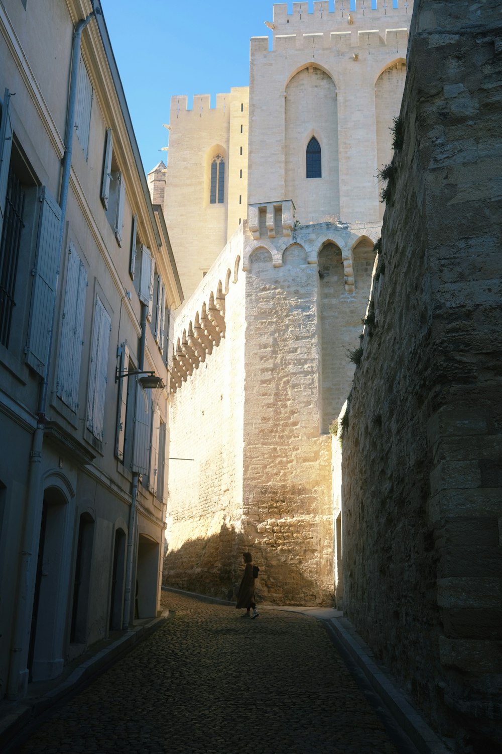 a person walking down a narrow alley way