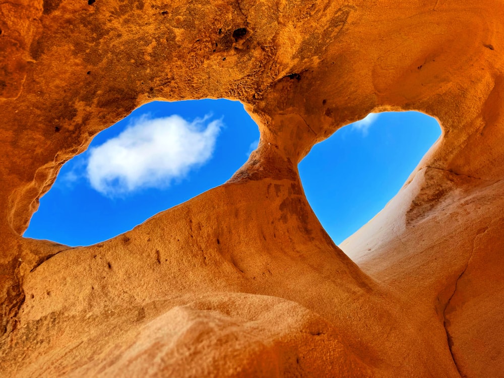 a view of the sky through a hole in a rock formation